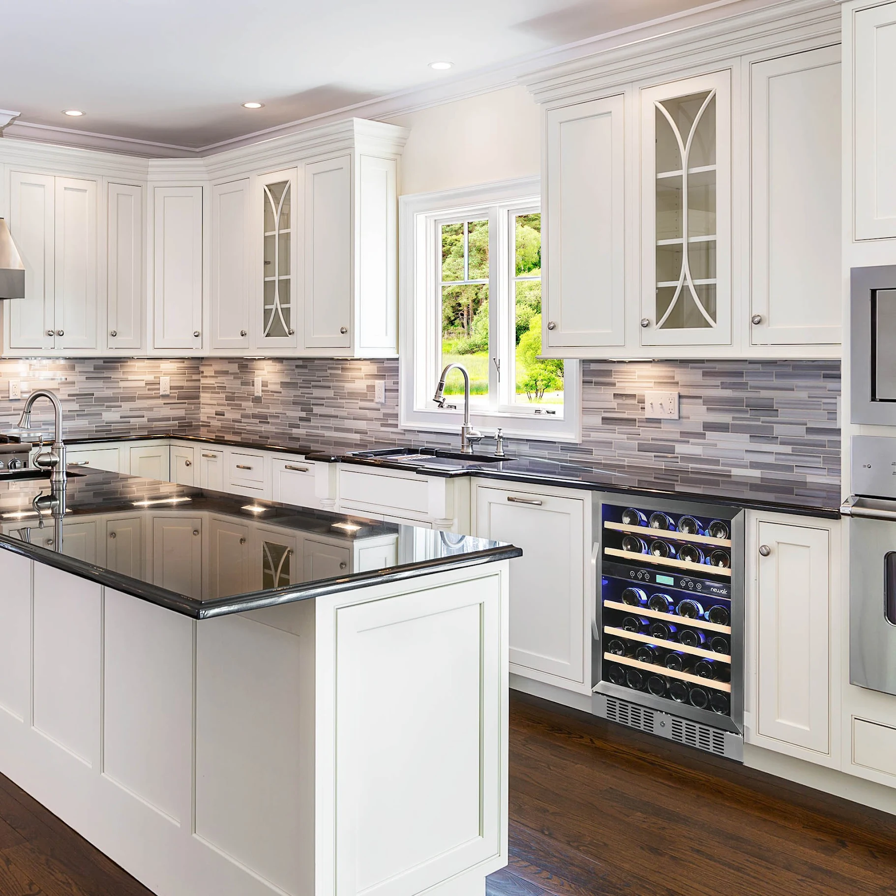 Renovated residential kitchen with white cabinetry, dark granite countertops, and a built-in wine refrigerator.